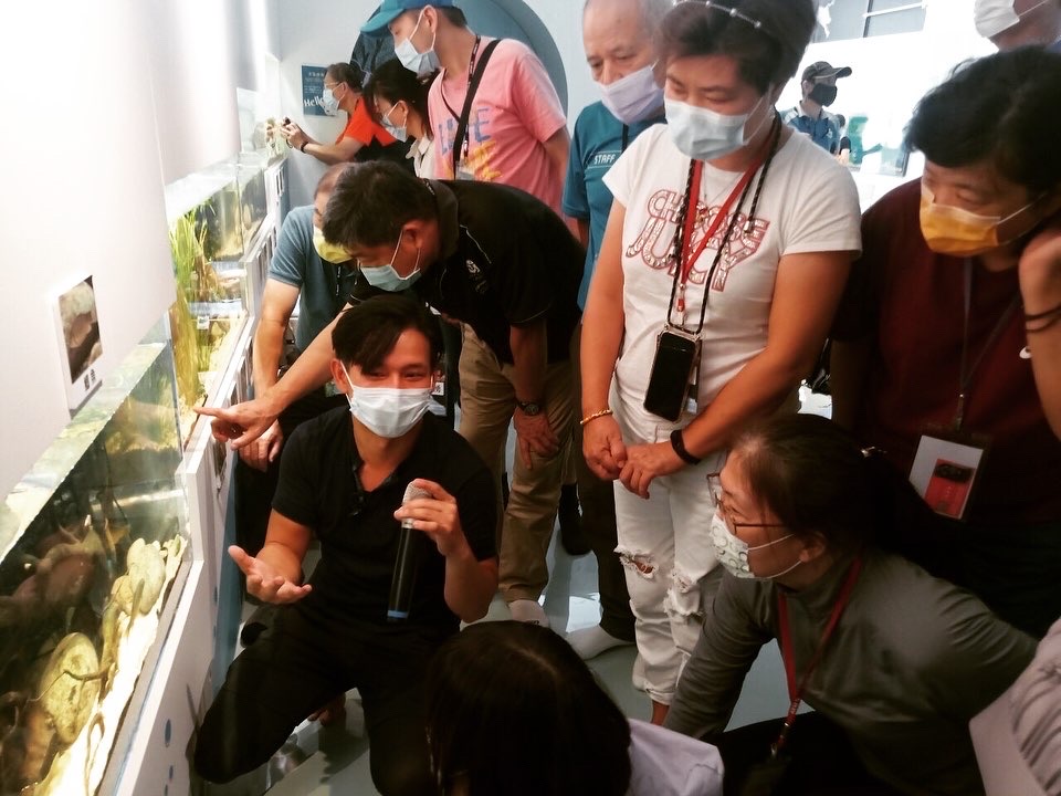 生態專業人員於展示空間中向參與人員說明生態調查資料與觀察重點 Ecological professionals explaining ecological survey data and key observations to participants in an exhibition space